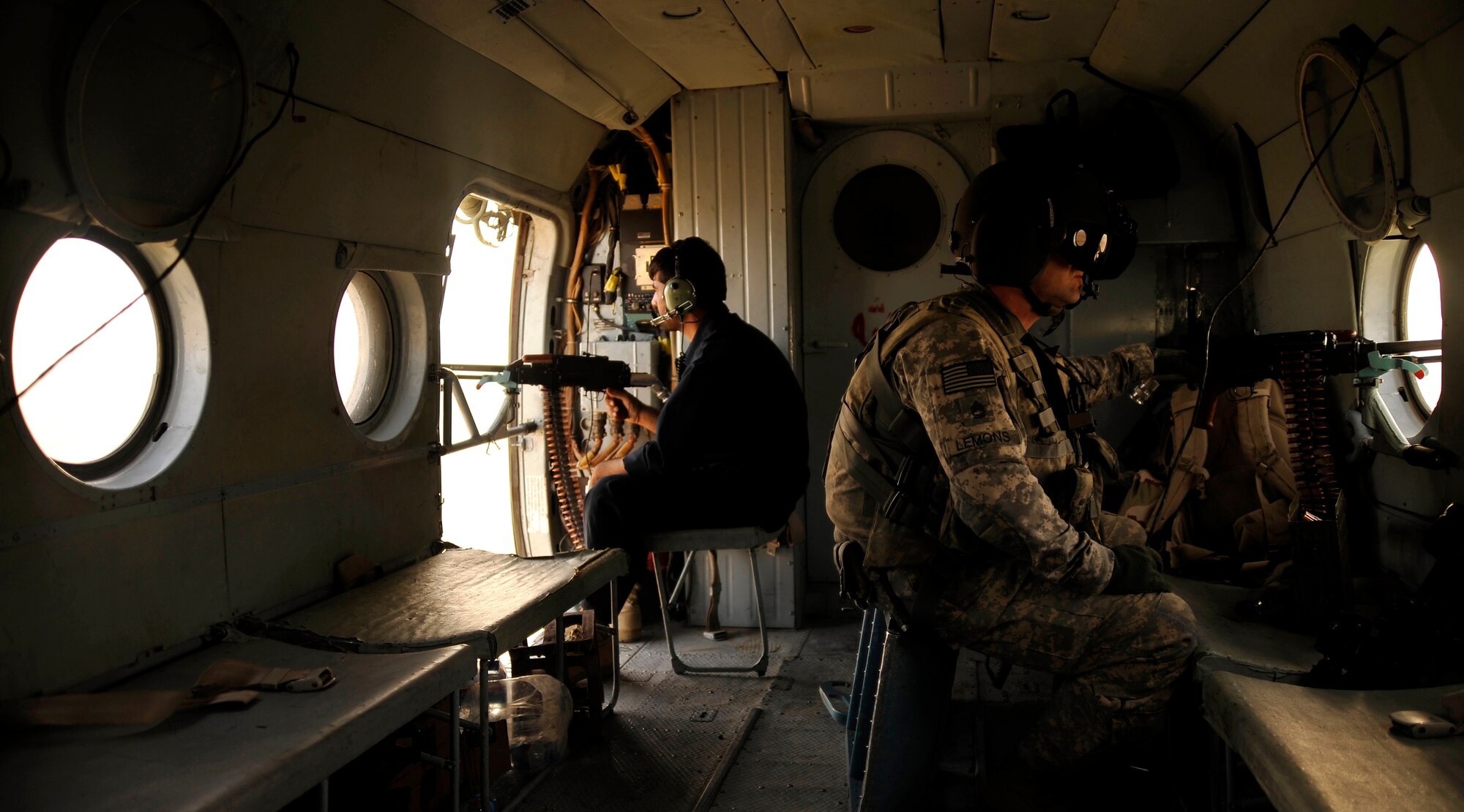 Army Sergeant First Class Joseph Lemons, ANNAC flight medic advisor from the 438th Air Expeditionary Training Group, and his Afghan counterpart provide surveillance and security aboard an Afghan-piloted Mi-35 Hind helicopter on a training sortie over southern Afghanistan Oct. 3, 2009.  (U.S. Air Force photo/Staff Sgt. Angelita Lawrence)