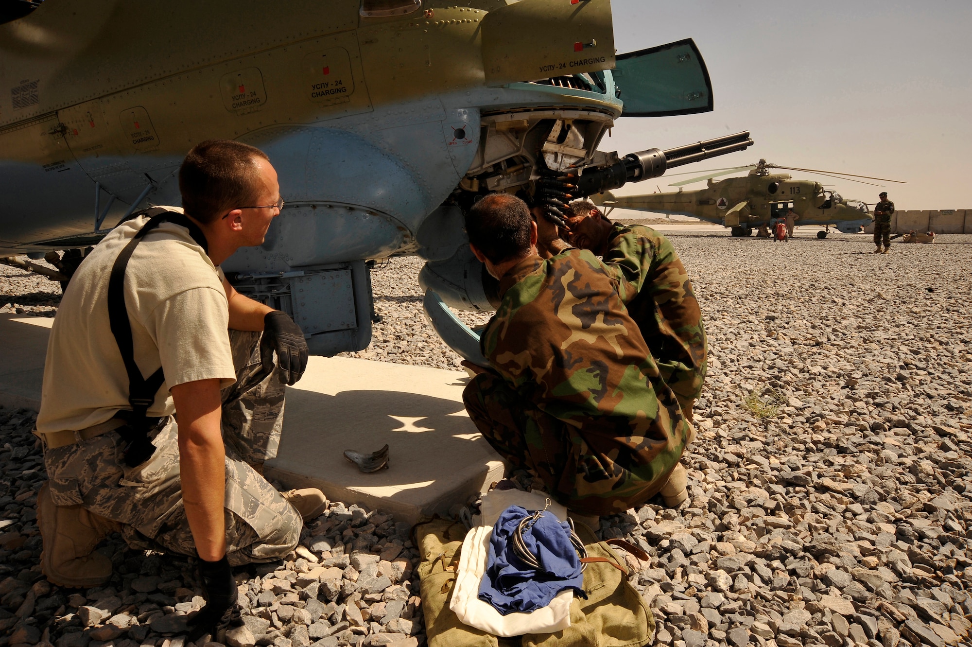 U.S. Air Force Staff Sgt. Cale Seubert, a munitions advisor from the 450th Air Expeditionary Training Squadron, stationed at Kandahar Air Field, assists his Afghan counterparts disarm an MI-35 "Hind" helicopter here Oct. 2, 2009.  The goal of the 450th AETS is to help the Afghans stand up their own air force. (U.S. Air Force photo/Staff Sgt. Angelita Lawrence)
