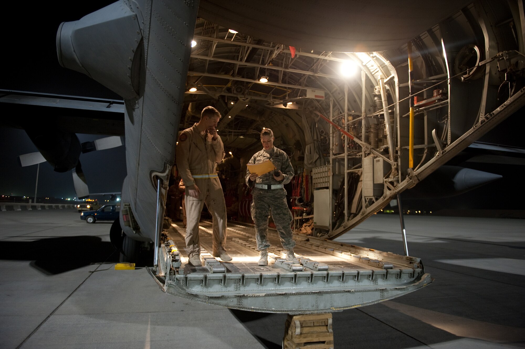 Right, U.S. Air Force Senior Airman Lacy Champion, 8th Expeditionary Air Mobility squadron air terminal operations center controller, checks the cargo and passenger manifest with Staff Sgt. Robert Farland, 30th Airlift Squadron loadmaster, Oct. 6, in Southwest Asia. Airman Champion helps ensure all local cargo aircraft have their cargo and passenger unloaded and loaded correctly, timely and safely. Airman Champion is deployed from Dover Air Force Base, Del., and Sergeant Farland is deployed from Cheyenne, Wyo., both are in support of Operations Iraqi and Enduring Freedom. (U.S. Air Force photo/Staff Sgt. Robert Barney/RELEASED) 