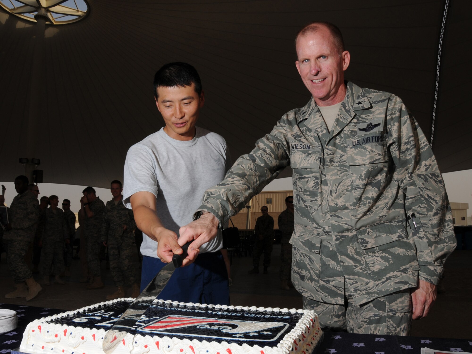Capt. Sang Lee, 379th Air Expeditionary Wing Combined Federal Campaign project officer, and Brig. Gen. Stephen Wilson, 379 AEW commander, cut the cake at the CFC kick-off event here, Oct. 6. The CFC raises millions of dollars each year between Sept. 1 and Dec. 15. (U.S. Air Force Photo/Tech Sgt. Jason W. Edwards)