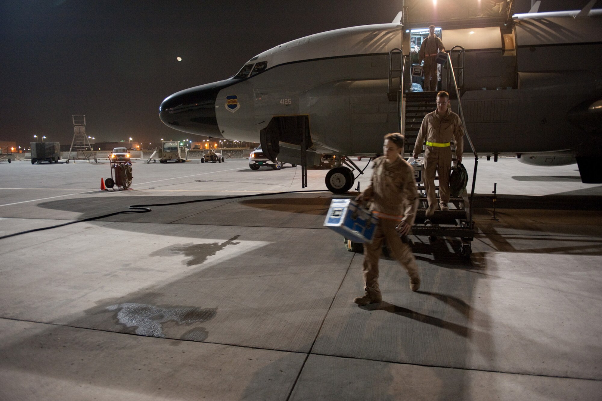 Crew members from the 763rd Expeditionary Reconnaissance Squadron exit the RC-135V/W Rivet Joint, Oct. 7, in Southwest Asia. The squadron marked the 7,000th consecutive day in the U.S. Central Command area of responsibility for the RC-135V/W Rivet Joint on Oct. 7. The 763 ERS is charged to provide commanders in the AOR near real-time on-scene intelligence collection, analysis and dissemination in support of Operations Iraqi and Enduring Freedom. (U.S. Air Force photo/Staff Sgt. Robert Barney) 