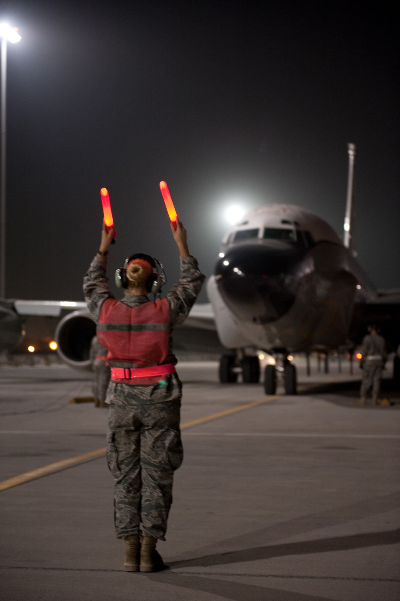 Senior Airman Jayme Warner, 55th Aircraft Maintenance Unit engine mechanic, guides a RC-135V/W Rivet Joint, Oct. 7, in Southwest Asia. Airman Warner helped mark Oct. 7 as the 7,000th consecutive day the Rivet Joint has provided commanders in the U.S. Central Command area of responsibility near real-time on-scene intelligence collection, analysis and dissemination. Airman Warner is deployed from Offutt Air Force Base, Neb., in support of Operations Iraqi and Enduring Freedom. (U.S. Air Force photo/Staff Sgt. Robert Barney) 