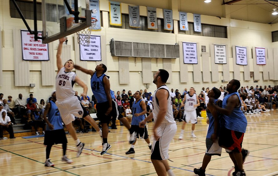 Eddie Gloviak, left, forward for the Dallas Baptist University Men's Basketball Team, goes up for a layup while being challenged by Team Osan's Julian Royal. The Team Osan Varisty Men's Basketball Team hosted DBU Oct. 6 at Osan American High School gymnasium. 42 students, coaches, staff and trainers from DBU traveled to Korea as part of the university's "Global Sports Initiative," playing Korean university teams as well as the Osan team. (U.S. Air Force photo/1st Lt. Chris Hoyler) 