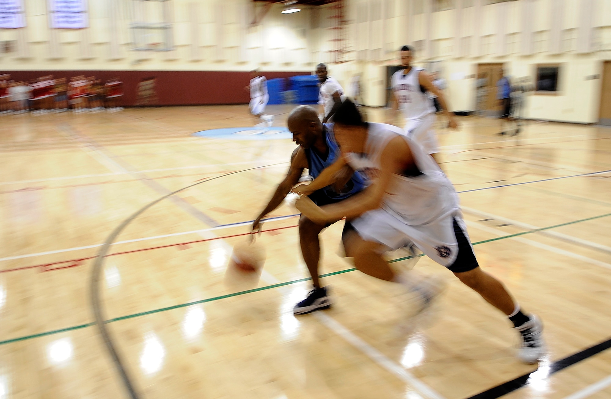 Raymar Bowen, left, a player for the Osan Air Base Varsity Basketball Team, controls a loose ball while a forward for Dallas Baptist University reaches in during a game Oct. 6. 42 students, coaches, staff and trainers from DBU traveled to Korea as part of the university's "Global Sports Initiative," playing Korean university teams as well as the Osan team. (U.S. Air Force photo/1st Lt. Chris Hoyler)