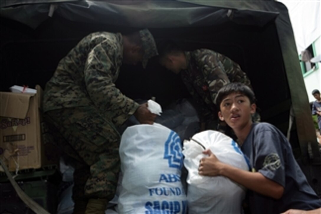 U.S. service members and members of the Armed Forces of the Philippines deliver family food packs to aid communities affected by tropical storm Ketsana in Manila, Philippines, on Oct. 4, 2009.  The food packs were donated by local businesses and other private organizations.  