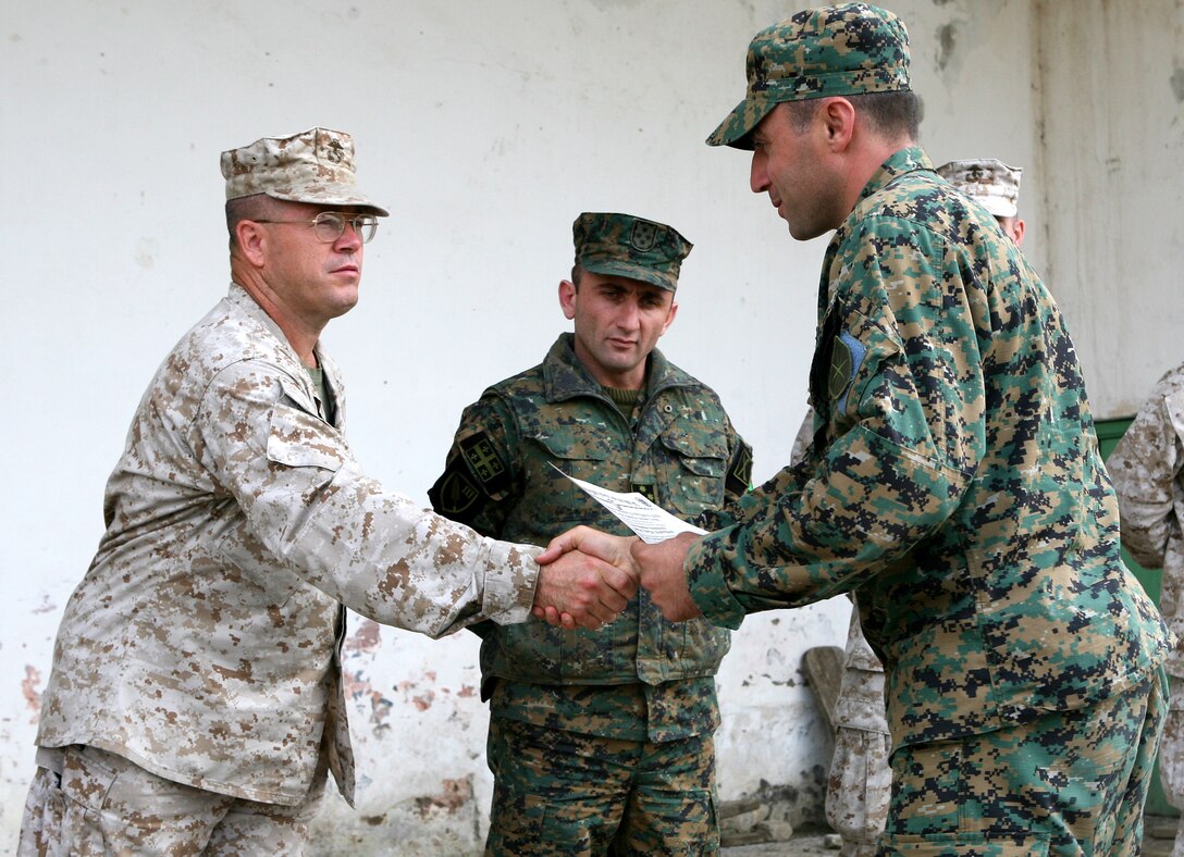 Lt. Col. Dan T. Thoele (left), deputy director of Marine Corps Training and Advisory Group and Georgian Training Team Leader, congratulates a Georgian soldier during a graduation ceremony October 9, 2009 held at Krtsanisi training facility.  The soldiers graduated from the Intelligence Preparation of the Battlefield course which was taught by three Marine instructors from Navy and Marine Corps Intelligence Training Center, Dam Neck, VA., and who are part of the Georgia Deployment Program in support of International Security Assistance Forces (GDP-ISAF).