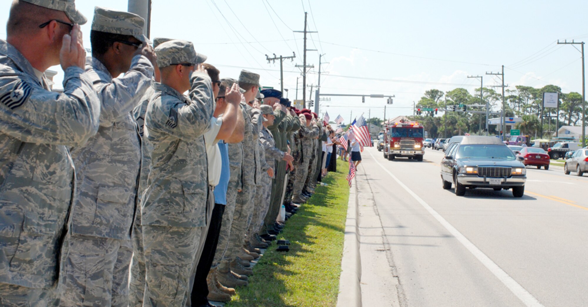 PATRICK AIR FORCE BASE, Fla. - A small beachside community wept and waved flags and a ribbon of hundreds of uniformed Airmen from here stood shoulder-to-shoulder with them along a two-mile stretch of road leading to a funeral home nearby October 8 to welcome home a local resident - 24-year-old fallen soldier, Army Sgt. Roberto Sanchez. (U.S. Air Force Photo/Staff Sgt. Leslie Kraushaar)