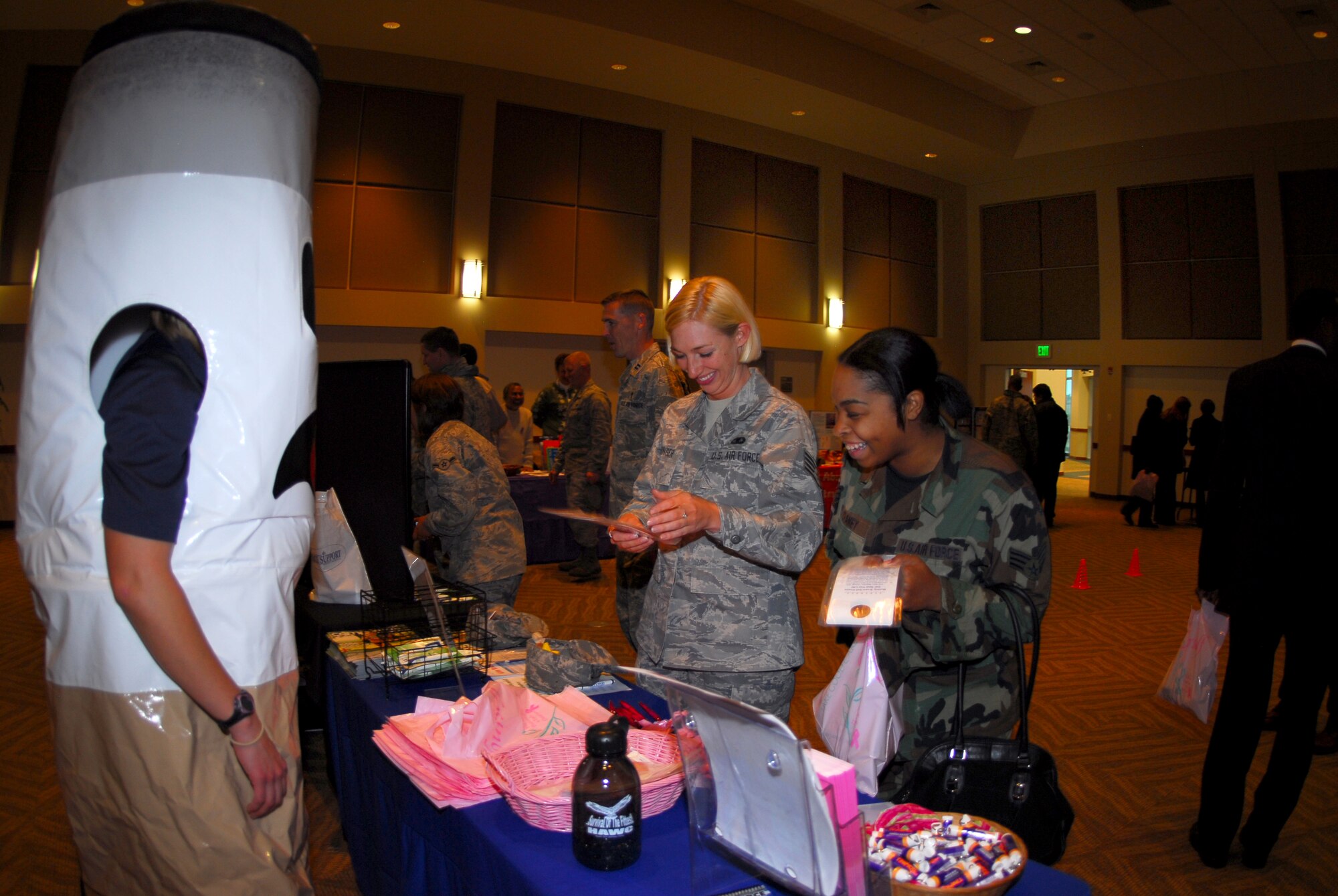 Buckley Air Force Base, Colo. — Staff Sgt. Ashley Wasinger and Senior Airman Evelyn Chaney, 460 Mission Support Group, chat with “Cigee the Butt” while getting information at the women's health booth at the Fall Safety Campaign Oct. 8. There were several booths set up to provide information on health awareness, home and driving safety. (U.S. Air Force photo by Staff Sgt. Anika K. Williams)