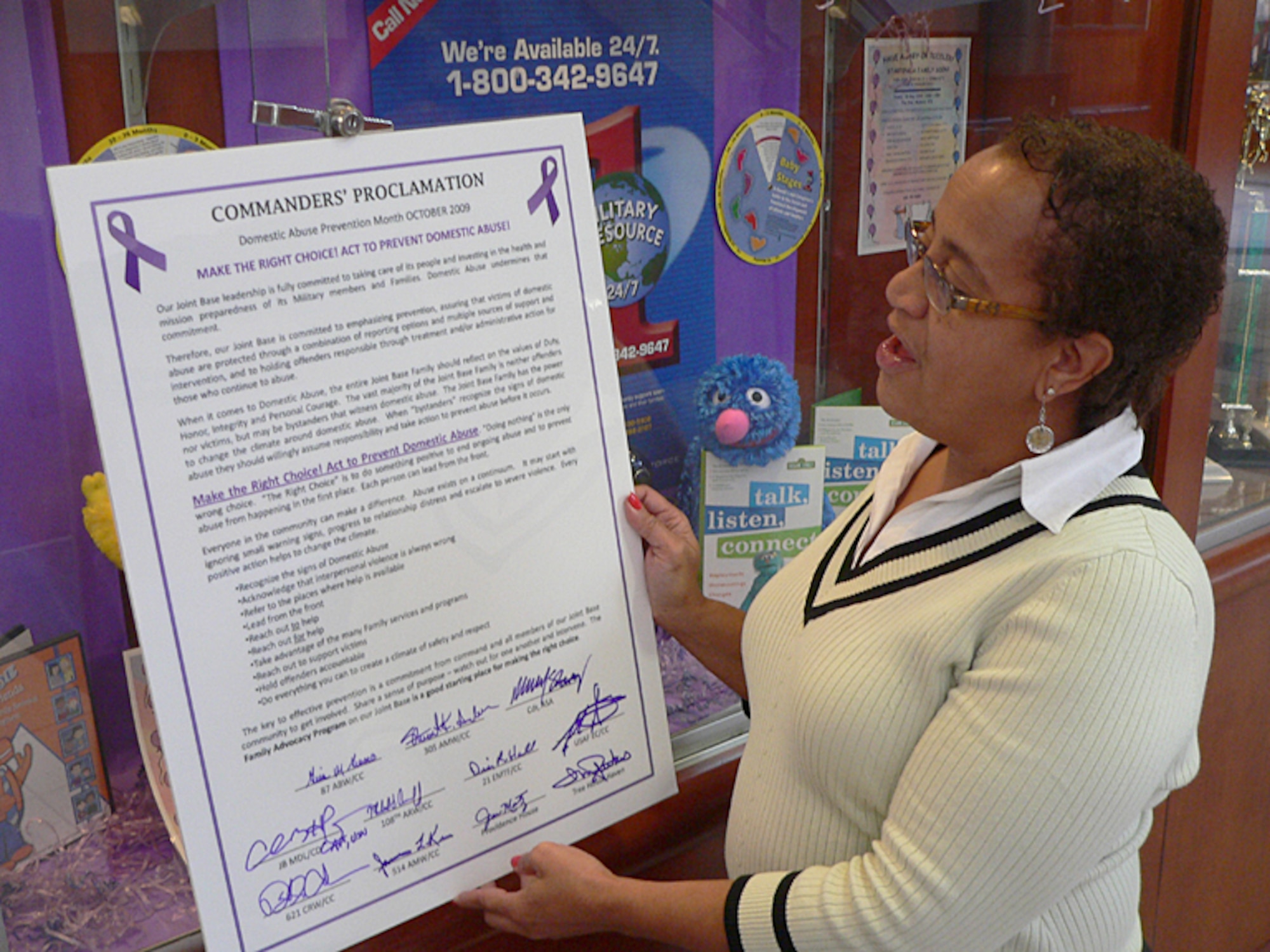 Joint Base Family Advocate Melodye Giovanni checks out a Department of Defense proclamation against domestic abuse that was signed by Joint Base McGuire-Dix-Lakehurst leaders at a symposium Oct. 6. (U.S. Air Force photo/Steve Snyder)