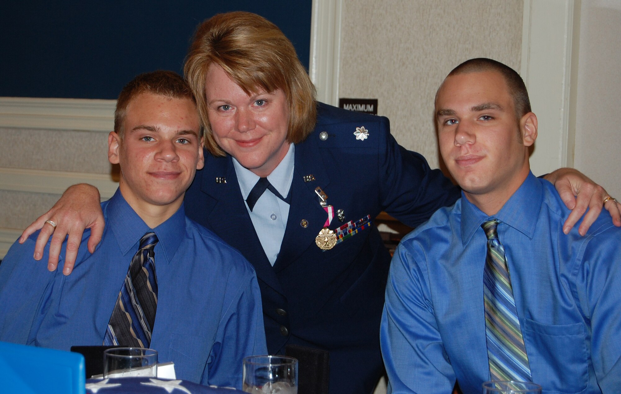 OFFUTT AIR FORCE BASE, Neb.  Lt. Col. Shelly R. Kinney, medical support flight commander with the 710th Medical Squadron, poses for a photograph with her two sons during the 710th mass retirement ceremony Oct. 3 at the Patriot Club. Colonel Kinney and nine other members of the 710th MDS retired during the event after serving with a total of more than 250 years in the U. S. Air Force. U.S. Air Force photo by Debbie Aragon
