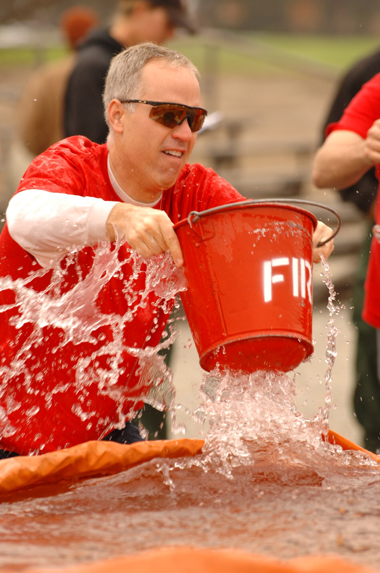 VANDENBERG AIR FORCE BASE, Calif. – Participating in a bucket brigade competition, Frank Kozak, from the 1st Air and Space Test Squadron, fills a bucket with water to help his team extinguish a simulated fire during the 3rd Annual Fire Muster Competition. Fire Vandenberg Fire celebrated Fire Prevention Week by hosting a number of fire-related events. (U.S. Air Force photo/Staff Sgt. Vanessa Valentine) 