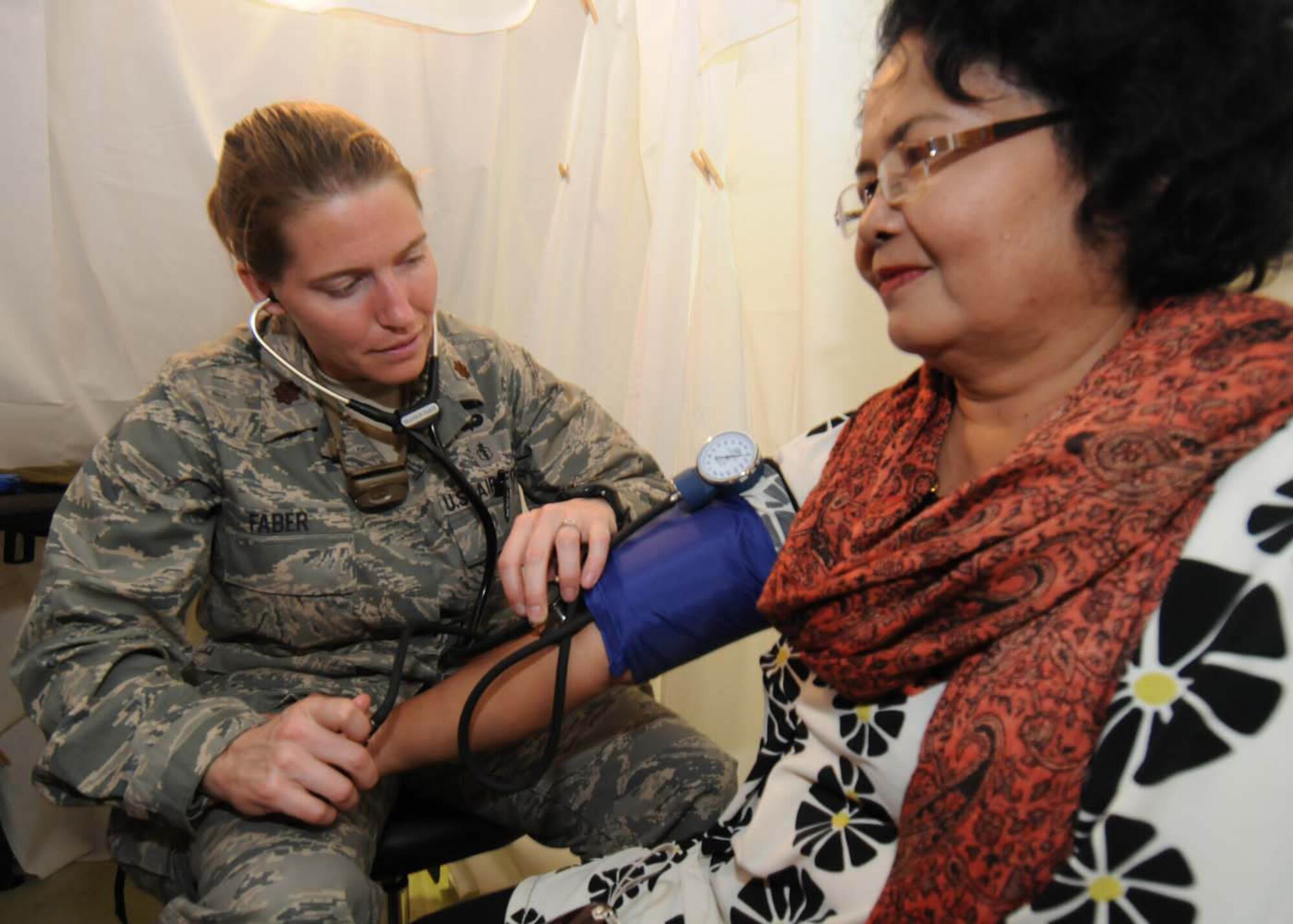 Maj. Shannon Faber checks a patient's blood presure during a medical assessment at a mobile field hospital in Padang, Indonesia, Oct. 8. Major Faber, an emergency medical doctor from the 3rd Medical Operations Squadron at Elmendorf Air Force Base, Alaska, is deployed here with an Air Force humanitarian assistance rapid response team. (U.S. Air Force photo/Staff Sgt. Veronica Pierce)