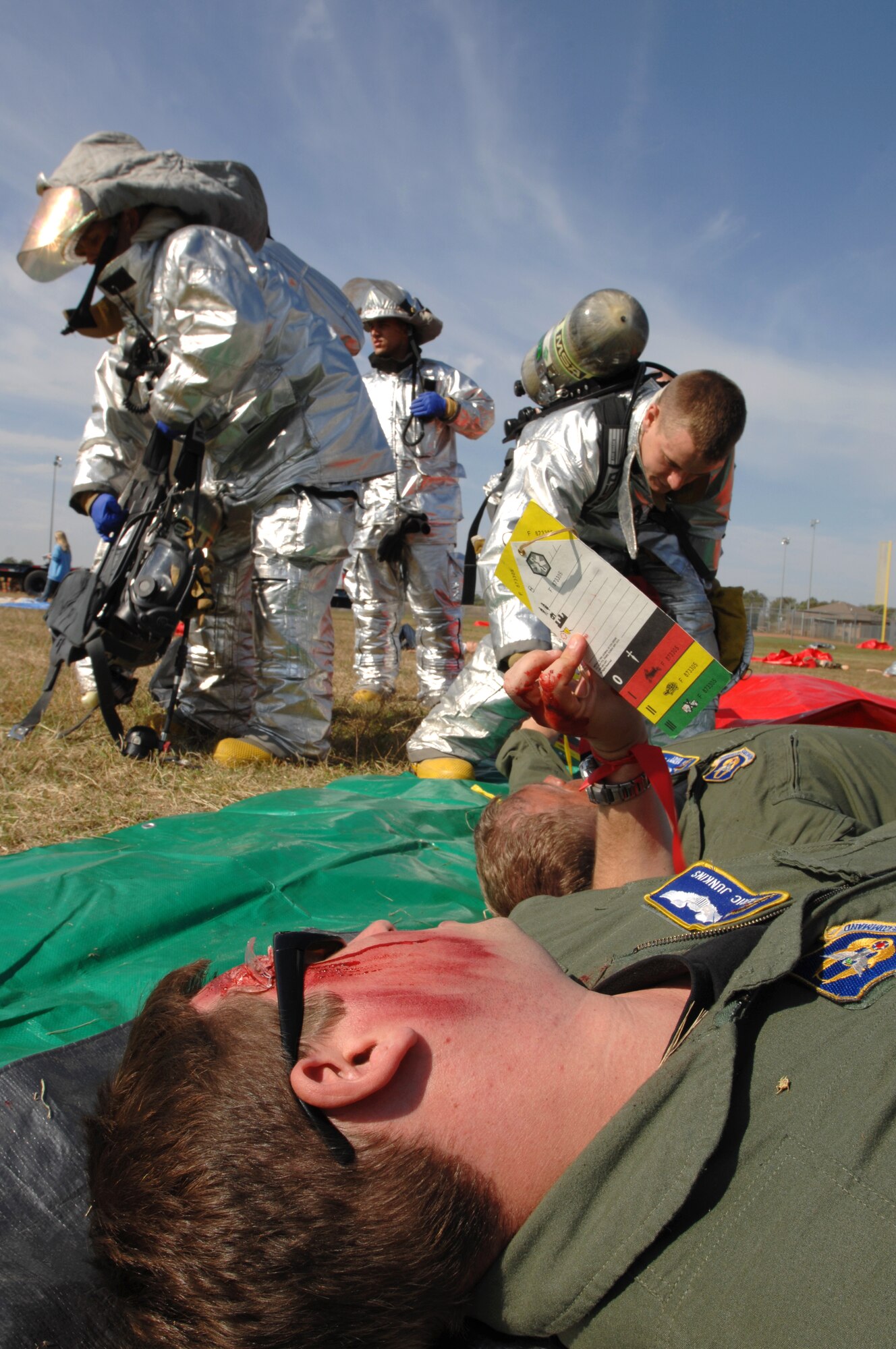 Capt. Eric Junkins, a Reservist from the 931st Air Refueling Group at McConnell Air Force Base, Kan., waits for 22nd Civil Engineer Squadron firemen treat his simulated injuries, Sept. 30, 2009, during a mass accident response exercise in Haysville, Kan. Volunteers, including students from Haysville High School, posed as accident victims with realistic-looking wounds and burns during the exercise.  (U.S. Air Force photo/Staff Sgt. Jamie Train)