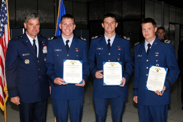 Brig. Gen. Samuel Cox poses for a photo with Cadets 2nd Class Bryan Koenig, Derrick Rowe and Alan Foote after presenting the cadets with Air Force Commendation Medals in Mitchell Hall Monday.The cadets, along with Cadet 1st Class Benjamin Garoutte, swam to the aid of three Panamanians at risk of drowning during a cultural immersion trip to Panama City in June. (U.S. Air Force photo/Bill Evans)