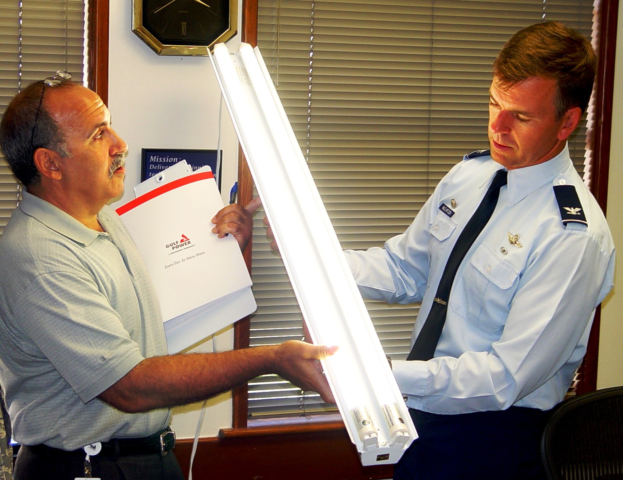 Bob Mantovani, Gulf Power, shows Col. Bruce McClintock, 96th ABW Commander, the new Light Emitting Diode (LED) technology to reduce energy.
