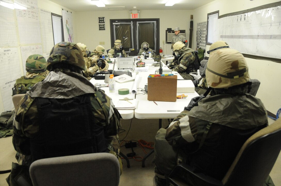 Airmen from the 28th Civil Engineer Squadron don protective gas masks during a Phase II Operational Readiness Exercise while in Mission Oriented Protective Posture gear here, October 7.  MOPP 4 gear consists of chemical warfare coat and pants, protective rubber boots, rubber gloves, helmet and gas mask. (U.S. Air Force photo/Airman 1st Class Anthony Sanchelli)