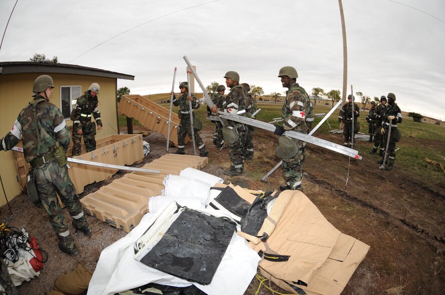 Airmen from the 28th Medical Group dismantle a tent during a Phase II Operational Readiness Exercise while in Mission Oriented Protective Posture gear here, October 7.  MOPP 2 gear consists of chemical warfare coat and pants, protective rubber boots, rubber gloves and helmet. (U.S. Air Force photo/Airman 1st Class Anthony Sanchelli)
