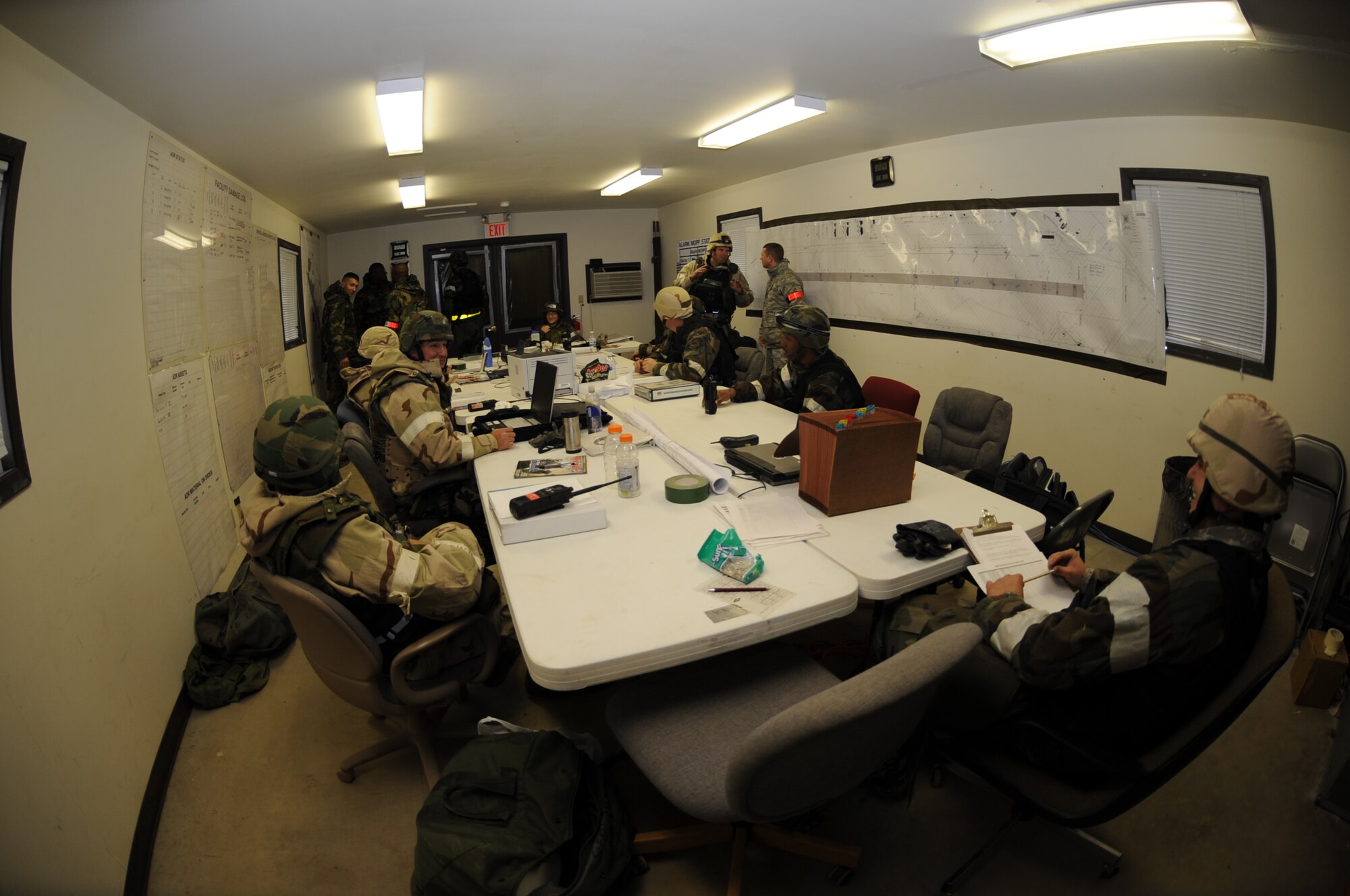 Airmen from the 28th Civil Engineer Squadron discuss strategies during a Phase II Operational Readiness Exercise while in Mission Oriented Protective Posture gear here, October 7.  MOPP 2 gear consists of chemical warfare coat and pants, protective rubber boots, rubber gloves and helmet. (U.S. Air Force photo/Airman 1st Class Anthony Sanchelli)
