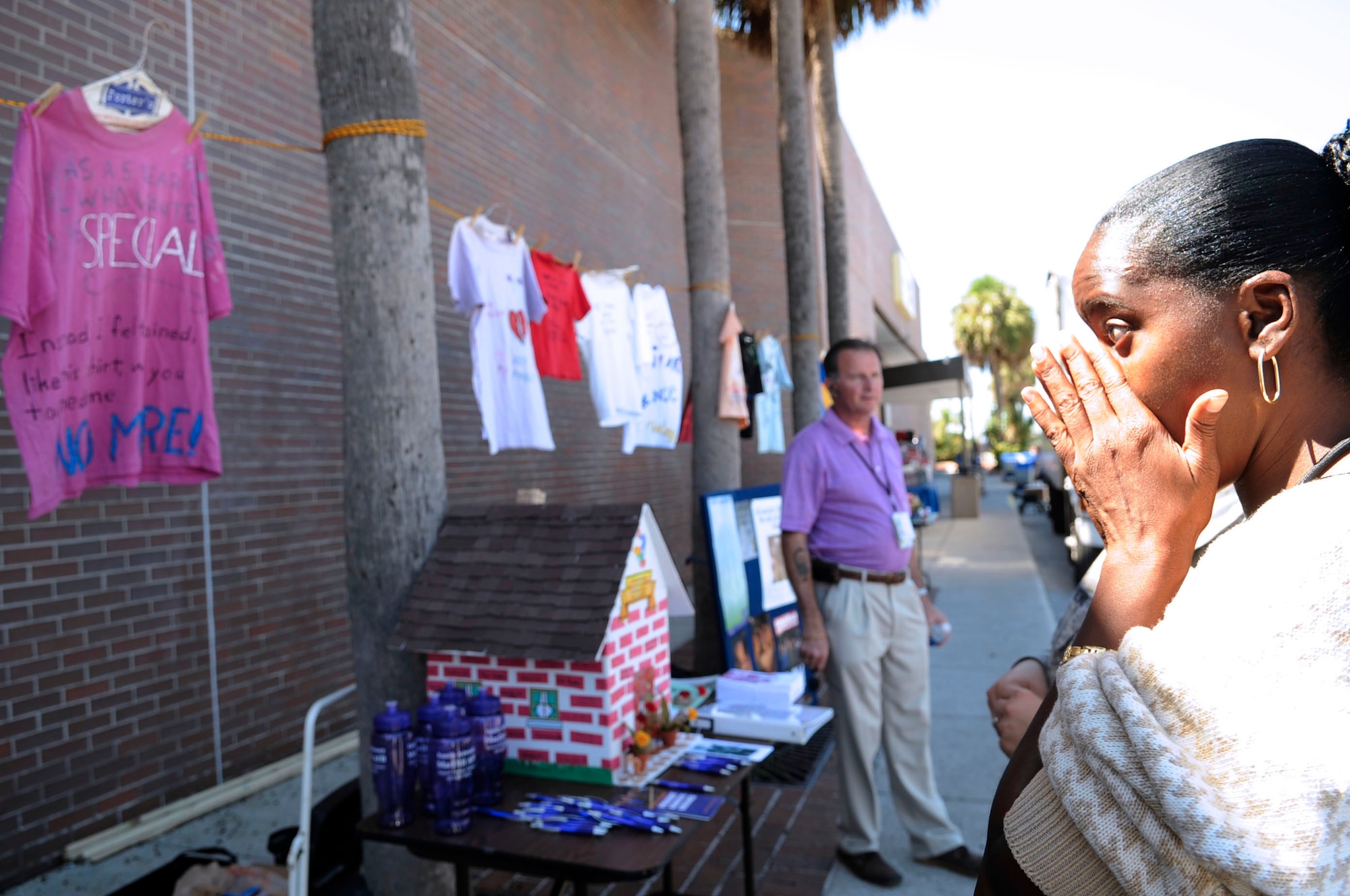 Lena Thomas, U.S. Special Operations Command system acquisition manager, sympathizes with all the women and children who have been abused during the clothesline project for Domestic Violence Awareness Month, here Oct. 1.  The clothesline project is designed to help women and children break the silence about violence by creating shirts that give voice to their personal experience.  (U.S. Air Force photographer Senior Airman Nancy Hooks, released)