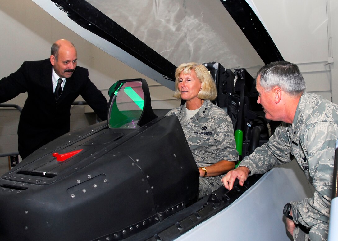 Maj. Gen. Mary K. Hertog, commander of 2nd Air Force, sits in an F-22 Raptor trainer at the Fifth Generation Aircraft Maintenance Facility during her Oct. 5-7 visit. Also pictured include (right) Brig. Gen. O.G. Mannon, 82nd Training Wing commander, and Stephen Stines, the F-22 Program director. (U.S. Air Force photo/Harry Tonemah)