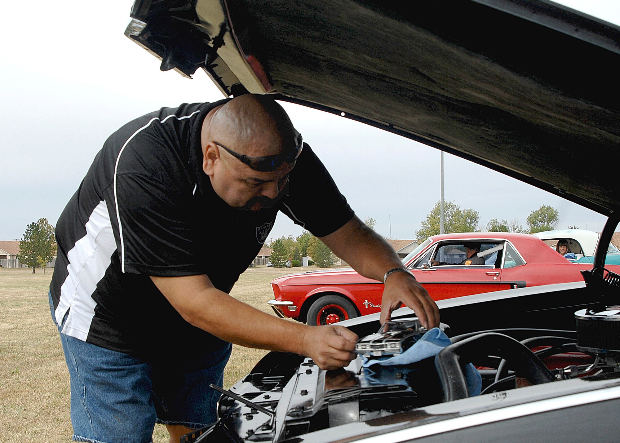 CANNON AIR FORCE BASE, N.M. -- Mateo Bando, places a model of his 1968 Oldsmobile 442 on the radiator of his muscle car Olds 442 during the third annual Cannon Thunder Auto Show Oct. 2 at Doc Stewart Park. A total of 64 automobiles and motorcycleswere on display in seven categories. (U.S. Air Force photo by Greg Allen) 