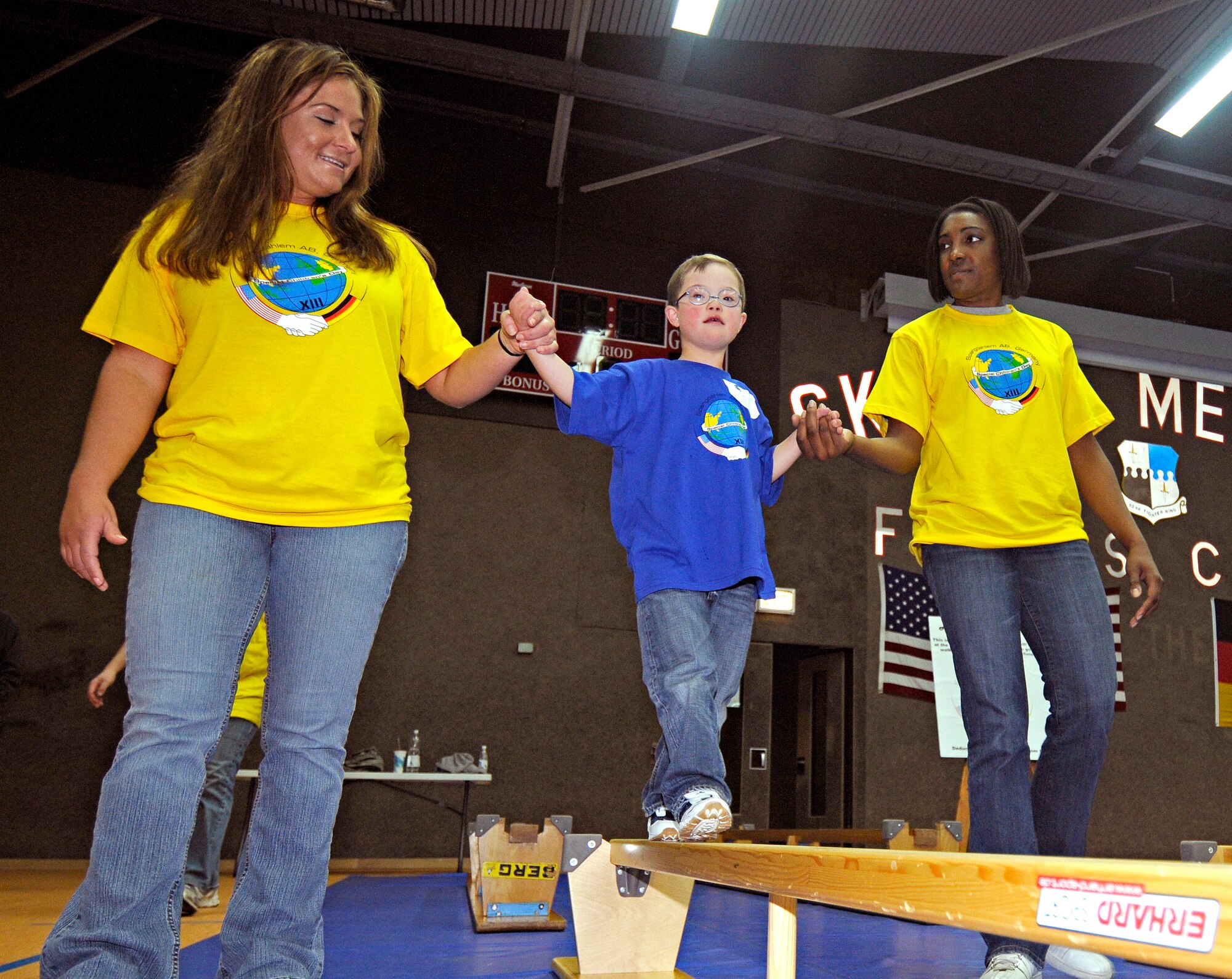 SPANGDAHLEM AIR BASE, Germany – Two Saber volunteers help Nils Collins walk across a balance beam Oct. 8. Nils was one of about 100 children with special needs from Bitburg’s St. Martin’s School and Department of Defense Dependants Schools-Europe to attend the Special Children’s Day held at the Skelton Memorial Fitness Center. The event required about 200 volunteers to help the children with games, lunch and an award ceremony at the end. (U.S. Air Force photo/Senior Airman Benjamin Wilson)