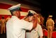 Newly pinned Chief Robert Ambol is presented his chief petty officer combination cover by Chief Yeoman Robert Dunn of Fleet Air Reconnaissance Squadron FOUR during a ceremony at Rose State College. Chief Ambol was one of 21 Sailors to recieve their anchors of gold following six weeks of CPO induction. (Navy Photo by Petty Officer 2nd Class Jessica R. Vargas)