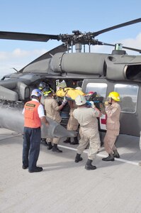 SOTO CANO AIR BASE, Honduras — A group of 24 Honduran firefighters practice loading, unloading and arm signals during the litter training Oct. 7 at the base flightline. The JTF-Bravo firefighters and 228th Aviations Regiment worked with the Honduran firefighters to bring them up to speed on different aircraft procedures used here in case the firefighters ever have to work together in the local community. Some of the training included litter training, aircraft training and general firefighter safety and procedures (U.S. Air Force photo/Staff Sgt. Chad Thompson).