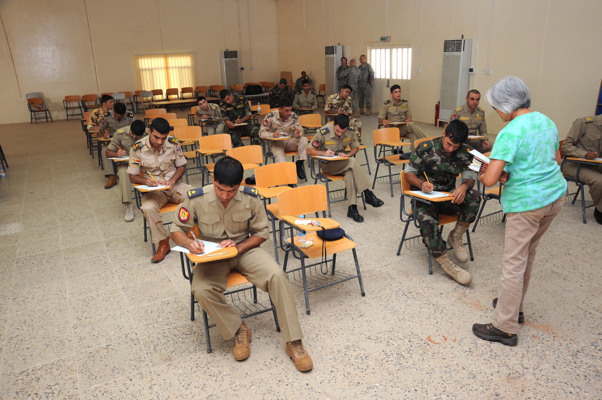Iraqi air force officers prepare to begin their monthly English evaluation as an instructor from the 821st Expeditionary Training Squadron gives directions Oct. 4, 2009, at Camp Taji, Iraq. Learning English is one of the Iraqi air force's core values and students must successfully complete the course before moving on to pilot training. U.S. Air Force instructors assigned to the 821st ETS facilitate the courses and serve as advisers to their Iraqi counterparts. (U.S. Air Force photo/Tech. Sgt. Johnny L. Saldivar)