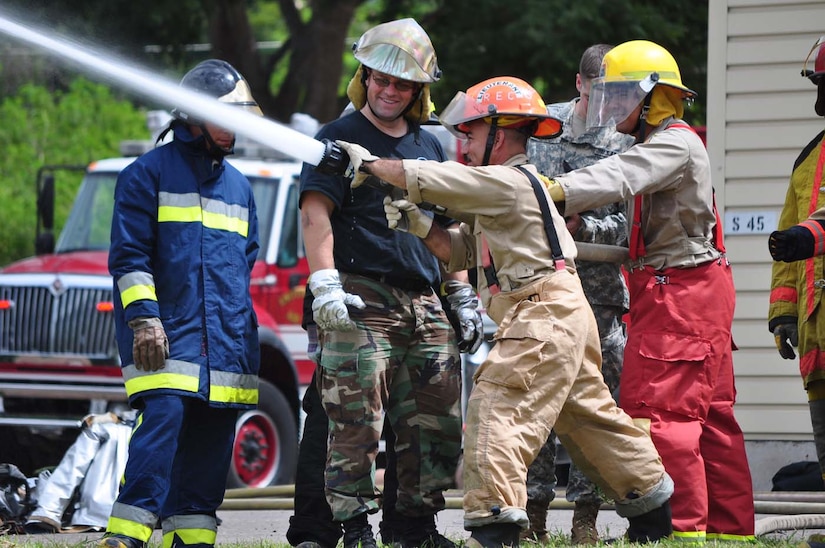 SOTO CANO AIR BASE, Honduras —Tech. Sgt. Clive Chipman, JTF-Bravo firefighter, instructs some Honduran firefighters on some proper techniques when spraying with high-pressure hoses Oct. 6 at the Soto Cano burn house. The JTF-Bravo firefighters worked with the Honduran firefighters to bring them up to speed on different procedures used here in case the firefighters ever have to work together in the local community. Some of the training included litter training, aircraft training and general firefighter safety and procedures (U.S. Air Force photo/Staff Sgt. Chad Thompson).
