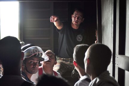 SOTO CANO AIR BASE, Honduras — Staff Sgt. Kahlil Davis, JTF-Bravo firefighter, gives the Honduran firefighters a safety briefing on how to enter and exit the Soto Cano burn house Oct. 6. The JTF-Bravo firefighters worked with the Honduran firefighters to bring them up to speed on different procedures used here in case the firefighters ever have to work together in the local community. Some of the training included litter training, aircraft training and general firefighter safety and procedures (U.S. Air Force photo/Staff Sgt. Chad Thompson).