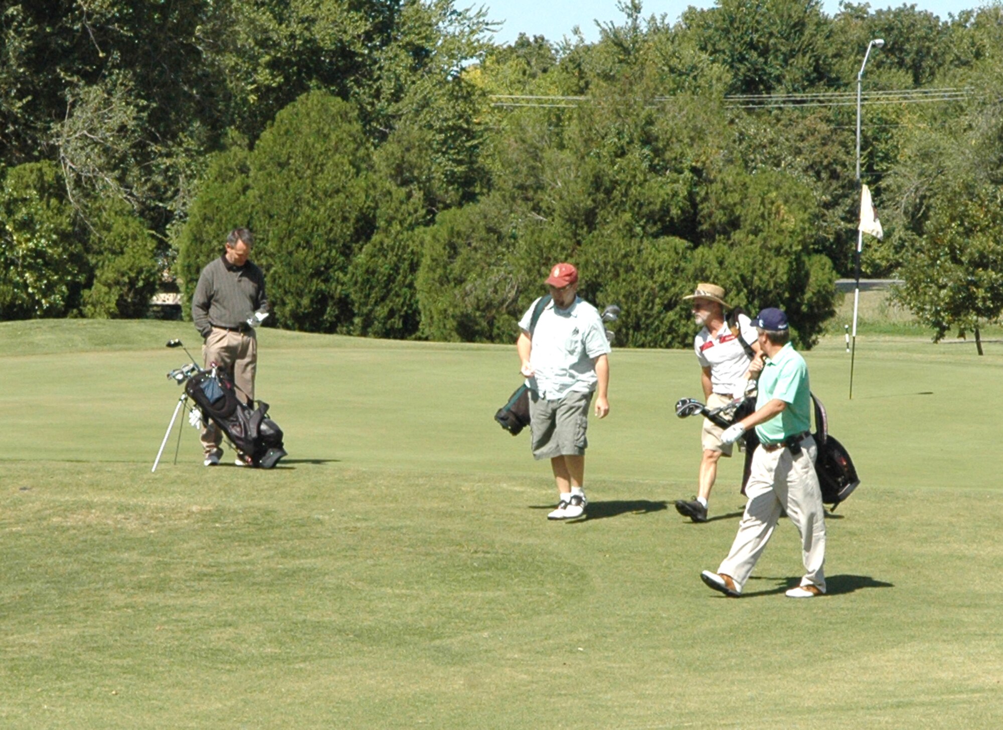 Members of the 72nd Civil Engineer Directorate took energy saving into their own hands, or legs, Oct. 2 during their Energy Awareness Golf Tournament. To save energy, the golfers walked the nine-hole course instead of riding in a golf cart. Gary McCracken, left, logs his team’s score as Charles Roberts, Bill Reed and Gene Gallogly, the base civil engineer, make their way to the tee box on hole No. 3. (Air Force photo by April McDonald)