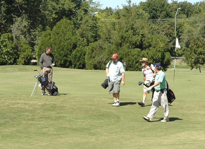 Members of the 72nd Civil Engineer Directorate took energy saving into their own hands, or legs, Oct. 2 during their Energy Awareness Golf Tournament. To save energy, the golfers walked the nine-hole course instead of riding in a golf cart. Gary McCracken, left, logs his team’s score as Charles Roberts, Bill Reed and Gene Gallogly, the base civil engineer, make their way to the tee box on hole No. 3. (Air Force photo by April McDonald)