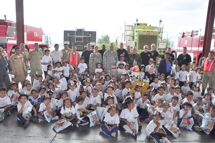 SOTO CANO AIR BASE, Honduras — Members of the Soto Cano fire department, Honduran fire department, volunteers and children pose for a group picture during the fire department’s fire prevention week “kid’s day” Oct. 6 at the fire department. About 175 children from different schools in La Paz and Comayagua traveled to base to learn some important lessons about fire prevention. The children got to tour the fire house, watch several demonstrations on how firefighters fight fires and they got to meet “Sparky the fire dog.” Every year during the week of Oct. 8 fire stations around the country reach out to the community to remind families of the importance of fire prevention (U.S. Air Force photo/Staff Sgt. Chad Thompson).