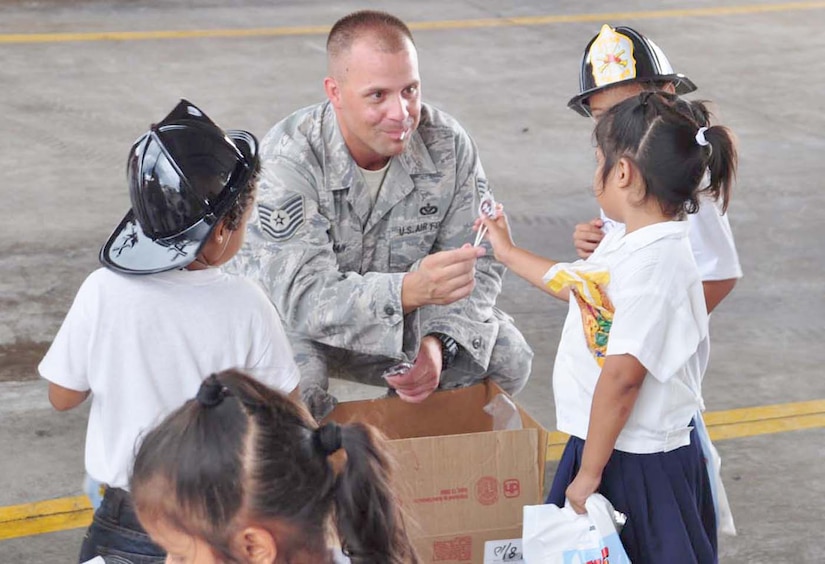 SOTO CANO AIR BASE, Honduras — Tech Sgt. Mike Cain, Joint Task Force-Bravo firefighter, hands out candy to some children during the fire department’s fire prevention week “kid’s day” here Oct. 6. About 175 children from different schools in La Paz and Comayagua traveled to base to learn some important lessons about fire prevention. The children got to tour the fire house, watch several demonstrations on how firefighters fight fires and they got to meet “Sparky the fire dog.” Every year during the week of Oct. 8 fire stations around the country reach out to the community to remind families of the importance of fire prevention (U.S. Air Force photo/Staff Sgt. Chad Thompson).