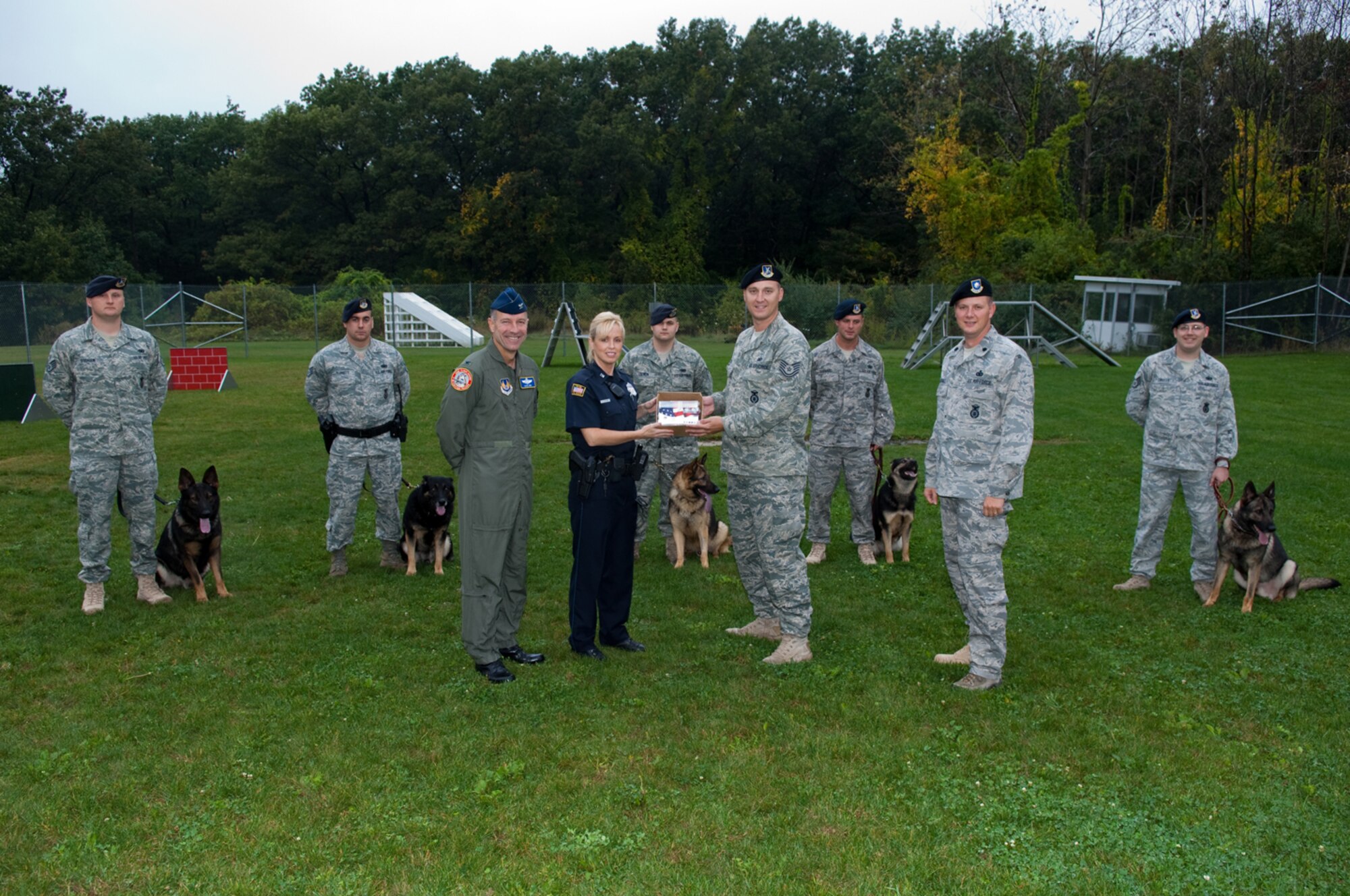 HANSCOM AIR FORCE BASE, Mass. - Officer Kristen Dineen, Bedford Police Department presents 400 prepaid calling cards to Tech Sergeant Andrew Limes of the 66th Security Forces Squadron, Military Working Dog Unit, Hanscom Air Force Base on Oct. 7.  Joining is the presentation is Colonel David Orr (left) 66th Air Base Wing commander and Lieutenant Colonel Chris Echols (right), 66th Security Forces Squadron commander.  (U.S. Air Force photo by Rick Berry)