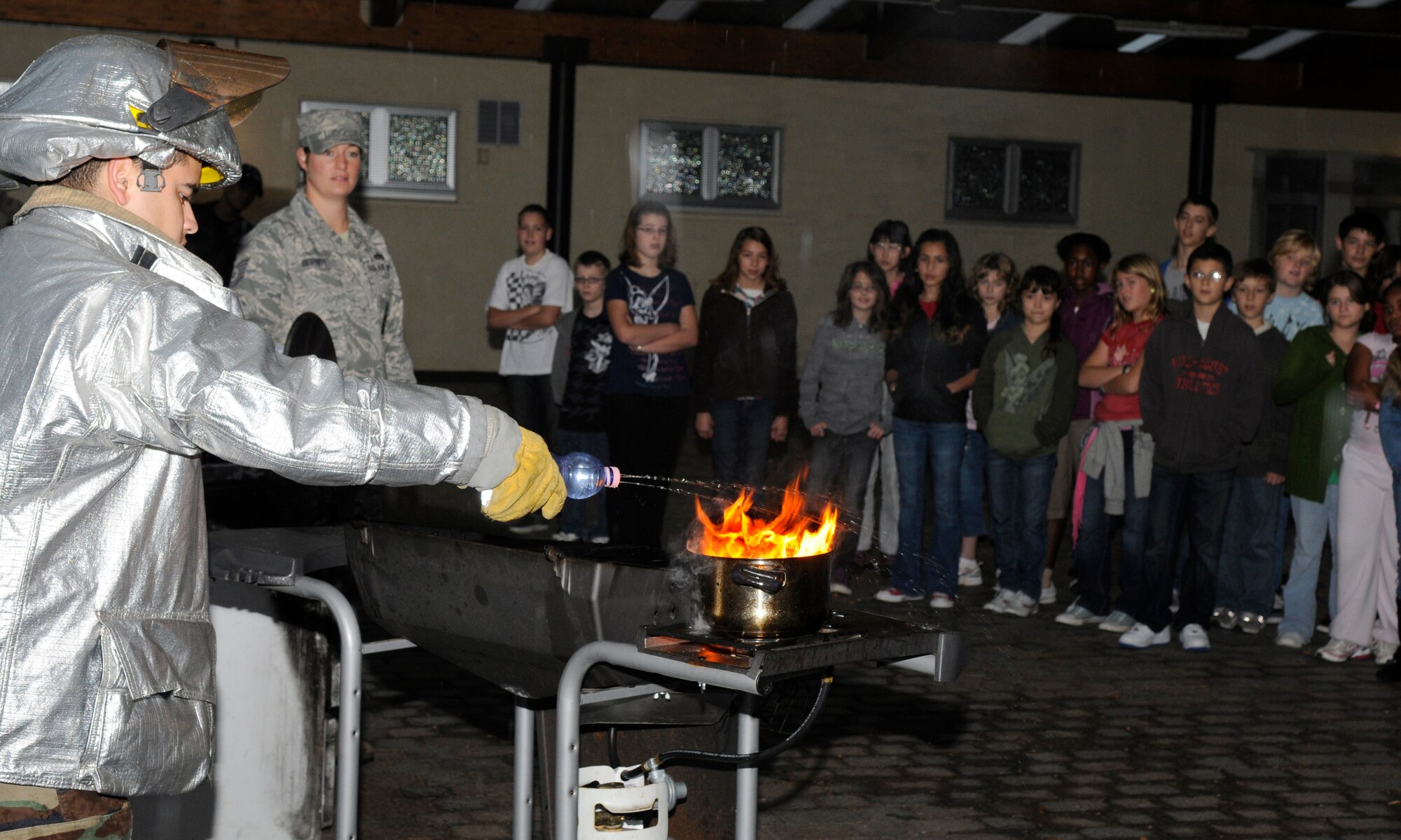 SPANGDAHLEM AIR BASE, Germany – Staff Sgt. Gary Day, 52nd Civil Engineer Squadron fire inspector, demonstrates the negative effect water has on a grease fire to Bitburg Middle School fifth and sixth graders Oct. 8. The fire inspectors then showed the students how to control the fire by covering the pan with a lid. Firefighters visited the middle school as part of Fire Prevention Week Oct. 4-10. (U.S. Air Force photo/Airman 1st Class Staci Miller)