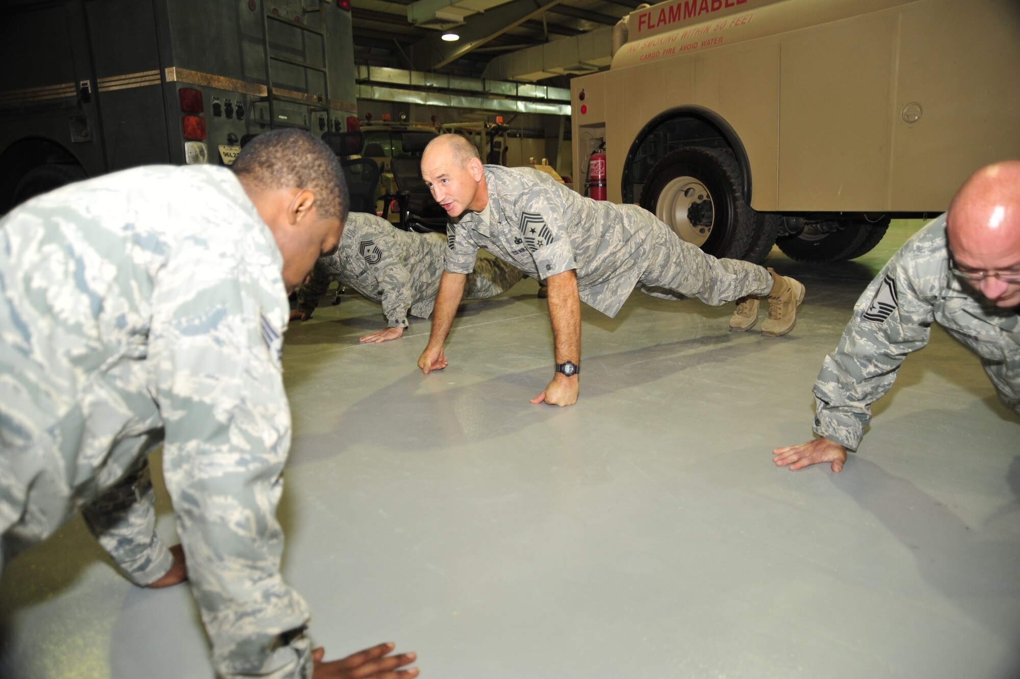SOUTHWEST ASIA – Chief Master Sgt. Stephen Sullens, command chief master sergeant for Air Combat Command, does push-ups with members of the 380th Expeditionary Logistics Readiness Squadron here Oct. 9, 2009. Chief Sullens is the sole enlisted advisor to the commander and staff for the enlisted force stationed at 25 wings, 15 bases and at more than 200 operating locations around the world. (U.S. Air Force photo/Tech. Sgt. Charles Larkin Sr.)