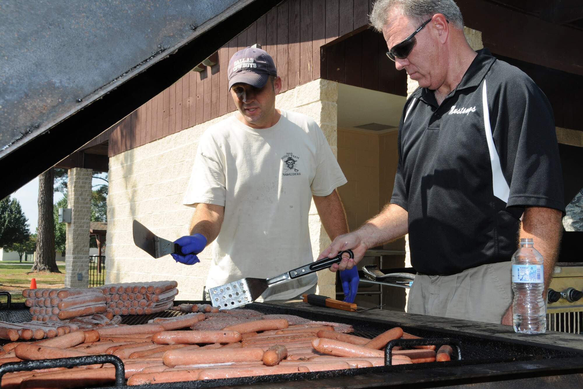 Members of the 916th Air Refueling Wing prepare hot dogs and hamburgers for the Family Day Picnic Oct. 3.  (U.S. Air Force photo by Gillian M. Albro, 916th ARW/PA)