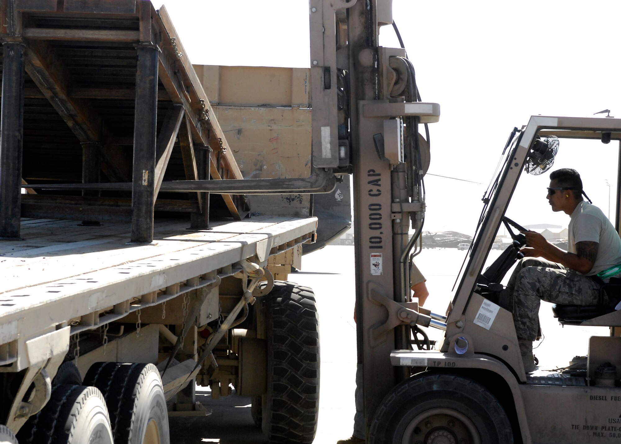 BAGRAM AIRFIELD, Afghanistan -- Senior Airman Alfred Garcia, a member of the ramp load team from the 455th Expeditionary Aerial Port Squadron, carefully lines the fork lift up so he can lift the ramp here, Oct. 9, 2009.  This mission essential ramp was offloaded and stored on the flightline by the 455th EAPS.  Airman Garcia, a San Antonio, Texas native, is deployed from Lackland Air Force Base, Texas.   (U.S. Air Force photo/Senior Airman Felicia Juenke)