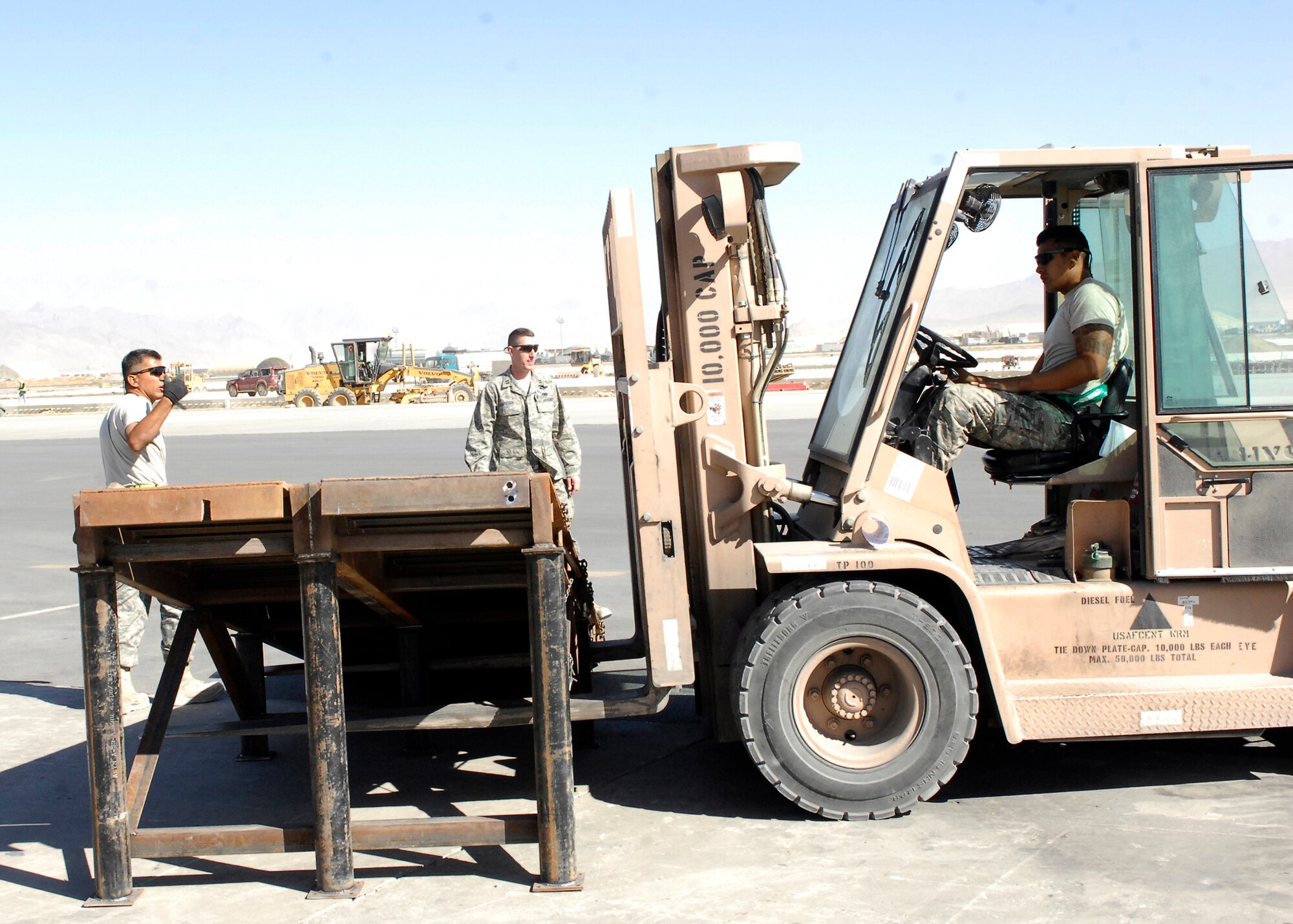 BAGRAM AIRFIELD, Afghanistan -- Master Sgt. Oscar Iruegas (left), the Ramp Supervisor form the 455th Expeditionary Aerial Port Squadron, directs Senior Airman Alfred Garcia (driving), a member of the ramp load team from the 455th EAPS, on where he needs to move the ramp here, Oct. 9, 2009.  This mission essential ramp was offloaded and stored on the flightline by the 455th EAPS.  Sergeant Iruegas and Airman Garcia are both deployed from Lackland Air Force Base, Texas and hail from San Antonio, Texas.  (U.S. Air Force photo/Senior Airman Felicia Juenke)