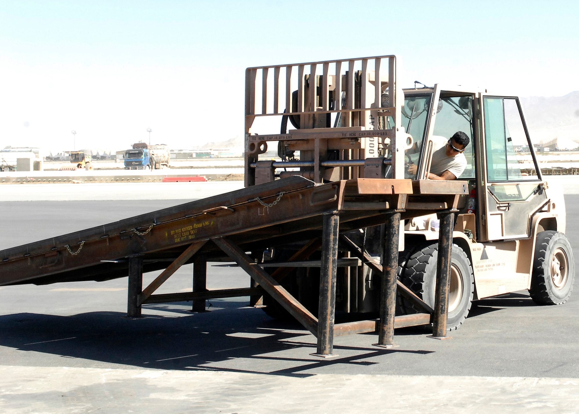 BAGRAM AIRFIELD, Afghanistan -- Senior Airman Alfred Garcia, a member of the ramp load team from the 455th Expeditionary Aerial Port Squadron, checks how much further he needs to move the ramp here, Oct. 9, 2009.  This mission essential ramp was offloaded and stored on the flightline by the 455th EAPS.  Airman Garcia, a San Antonio, Texas native, is deployed from Lackland Air Force Base, Texas.   (U.S. Air Force photo/Senior Airman Felicia Juenke)