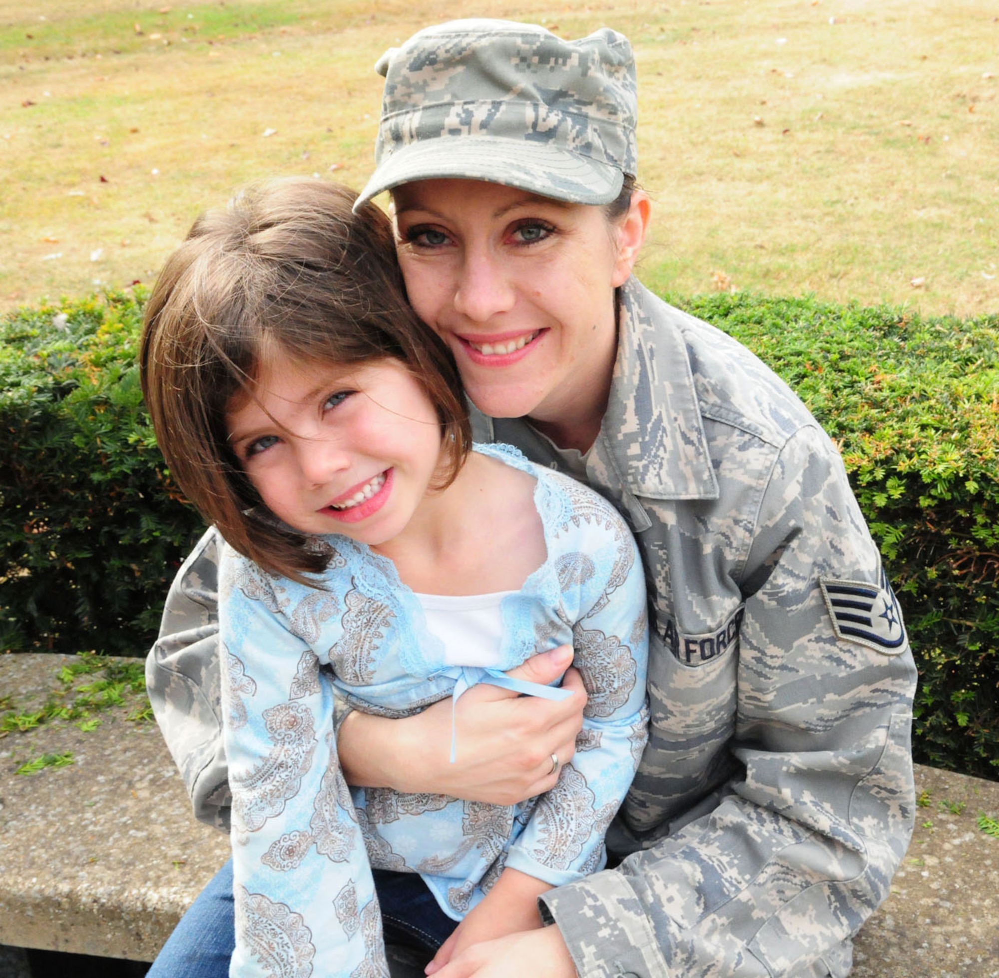 Noel Ingram, 4, poses with her mom, Staff Sgt. Alana Ingram, Defense Media Activity, U.K., NCOIC of broadcast operations, at RAF Feltwell, Oct. 2, 2009. When asked how proud she thought her mom was of her for donating her hair, Noel stretched her 4-year-old arms as wide apart as she could, and said 'This much." On the other hand, to demonstrate how proud she actually was of her daughter for doing this, Sergeant Ingram stretched out her adult-sized arms far further, and said, "No - this much!" (U.S. Air Force photo by Karen Abeyasekere)