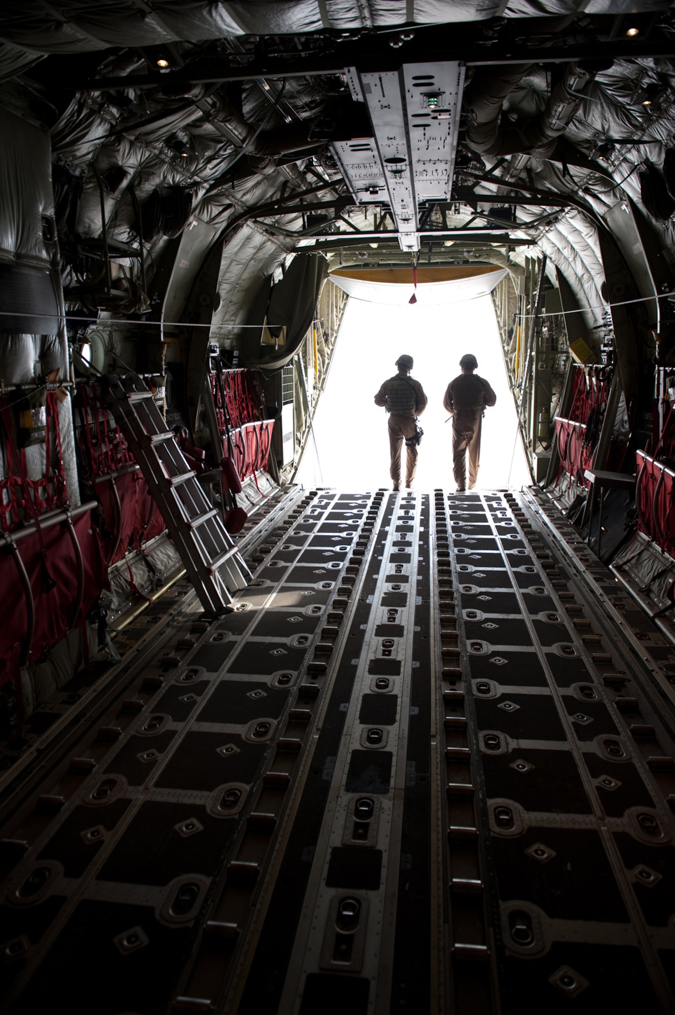 Right, Airman 1st Class Dustin Wiley and Senior Airman Brandon Owens, 379th Expeditionary Security Forces Squadron Fly Away Security Team members, exit a C-130 as they prepare to secure the area around the aircraft, Oct. 6, in Southwest Asia. Airmen Wiley and Owens ensure U.S. Air Force aircraft are secure when they travel to areas with less established security. Airman Wiley is deployed from RAF Mildenhall, England, and Airman Owens is from Bolling Air Force Base, Washington D.C. Both are deployed in support of Operations Iraqi and Enduring Freedom. (U.S. Air Force photo/Staff Sgt. Robert Barney)