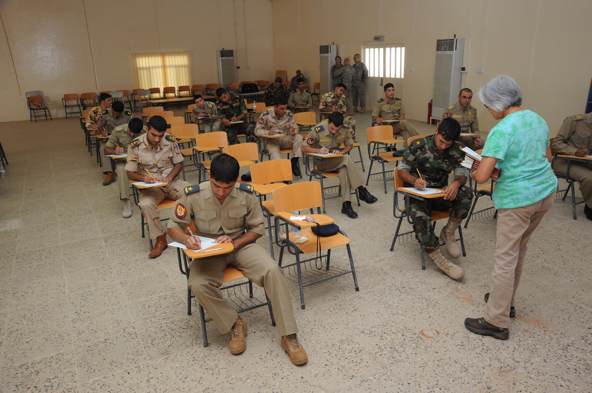 CAMP TAJI, Iraq -- Iraqi air force officers prepare to begin their monthly English evaluation as an instructor from the 821st Expeditionary Training Squadron gives directions here Oct. 4, 2009. Learning English is one of the Iraqi air force's core values and students must successfully complete the course before moving on to pilot training. U.S. Air Force instructors assigned to the 821st ETS facilitate the courses and serve as advisors to their Iraqi counterparts. (U.S. Air Force photo/Tech. Sgt. Johnny L. Saldivar)