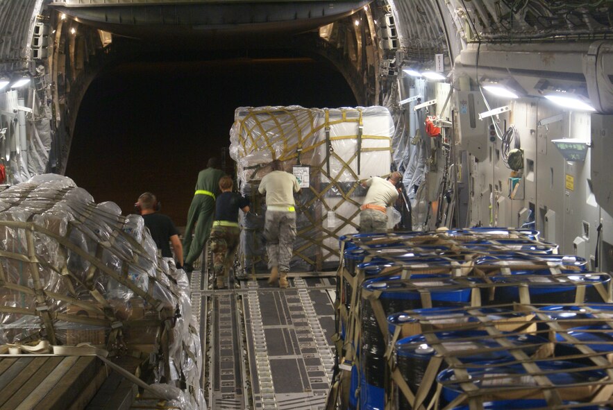 PADANG, Indonesia – 7th Airlift Squadron Airmen and members of the 36th Mobility Response Squadron, Andersen Air Force Base, Guam, off-load cargo from a McChord C-17 Globemaster III on a humanitarian mission Oct. 9 at Minangkabau International Airport. (U.S. Air Force photo/Staff Sgt. Eric Burks)