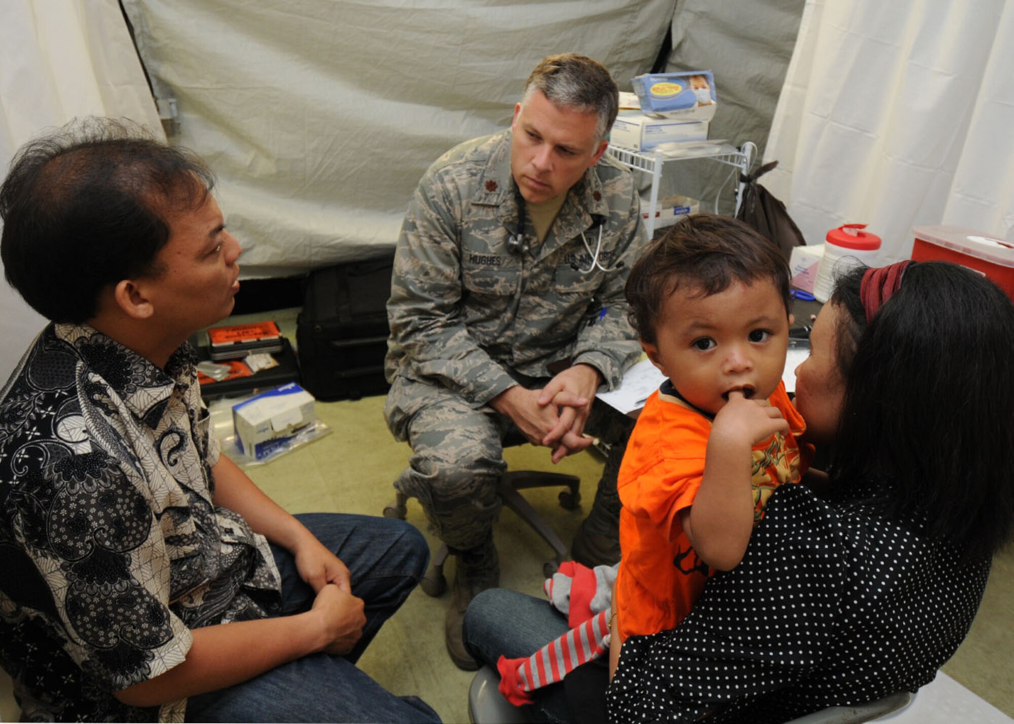 PADANG, Indonesia -- Maj. Scott Hughes gathers medical information from a patient with the help of Hasbi, a local interpreter, Oct. 10. Major Hughes is a doctor from the 36th Medical Group at Andersen Air Force Base, Guam, and is deployed here with a U.S. Air Force humanitarian assistance rapid response team to provide medical assistance to those affected by the recent earthquakes. (U.S. Air Force photo/Staff Sgt. Veronica Pierce)