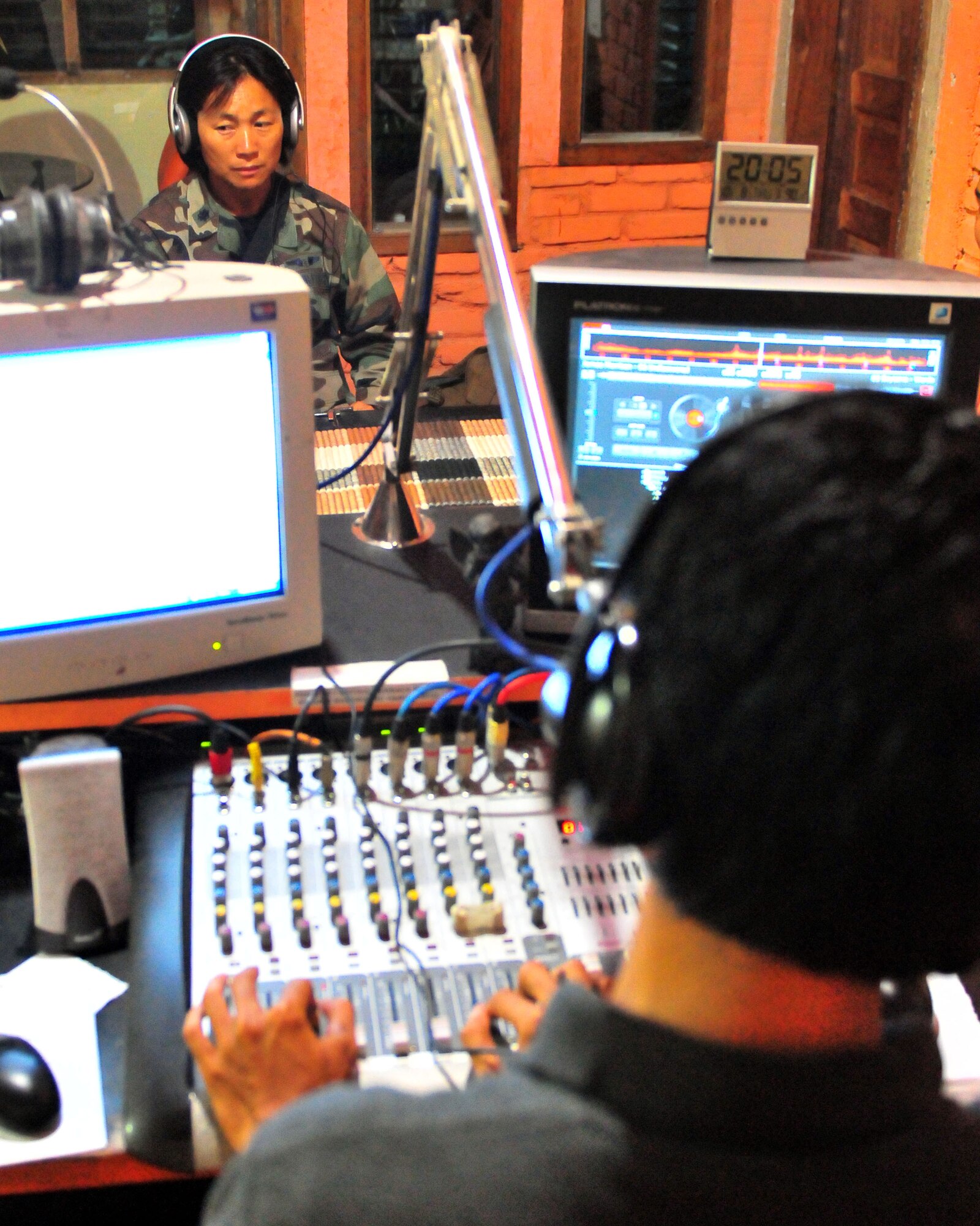PADANG, Indonesia -- Lt. Col. Peerach Ewings talks to a Aim Zen, a radio personality from Pro News 90 FM, during a Oct. 8 show about the capabilities of a U.S. Air Force mobile field hospital and that all services are free for people who need medical care. Colonel Ewings, a native of Fort Walton Beach, Fla., assigned to 13th Air Force at Hickam Air Force Base, Hawaii, is deployed here with a U.S. Air Force humanitarian assistance rapid response team. (U.S. Navy photograph/Chief Mass Communication Specialist (SW/AW) Ty Swartz)