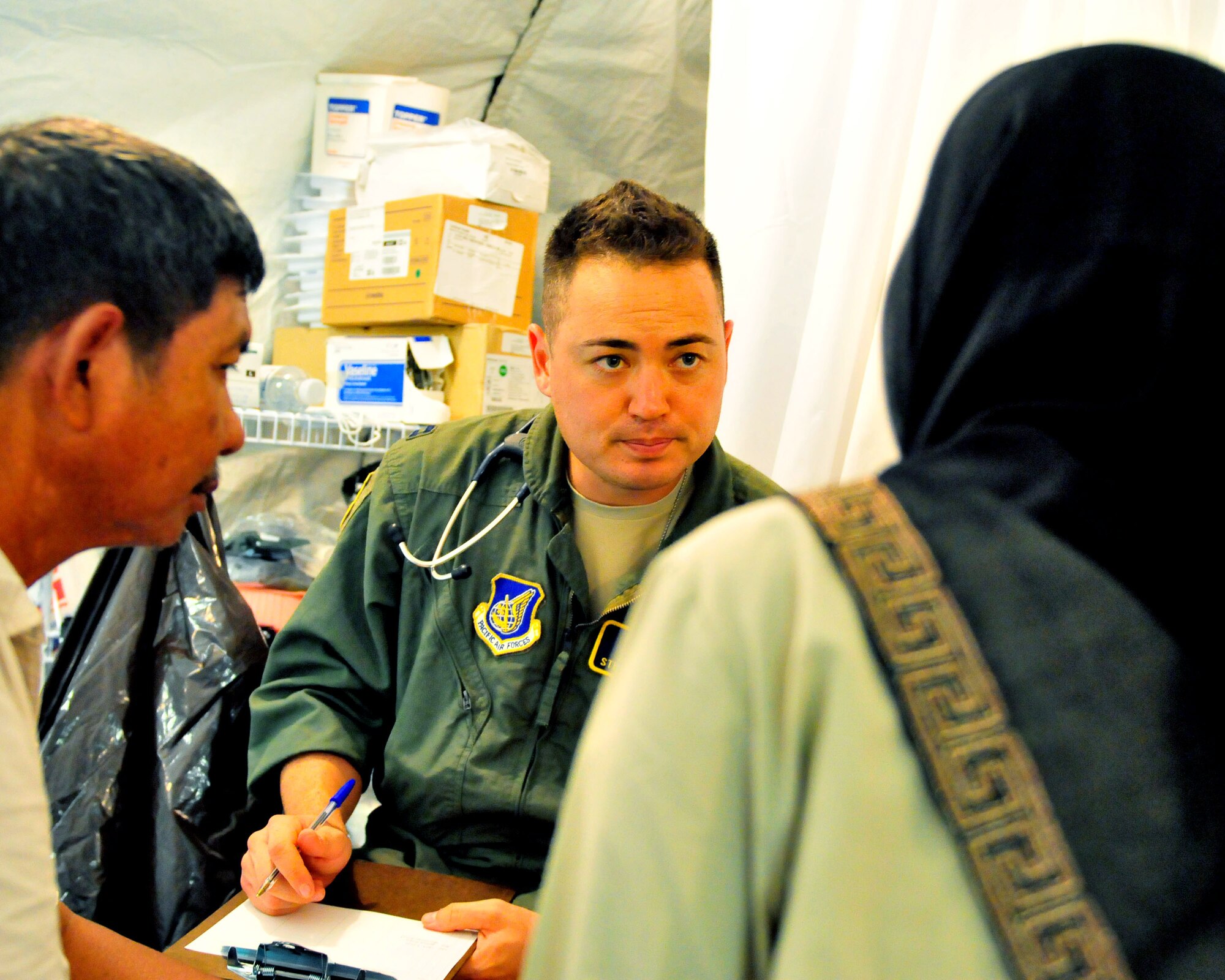 PADANG, Indonesia -- Capt. Steven Ellis listens to a patent during a medical history review at a mobile field hospital here Oct. 8. Captain Ellis, a native of Colorado Springs, Colo., assigned to the 36th Medical Operations Squadron at Andersen Air Force Base, Guam, is deployed here with a U.S. Air Force humanitarian assistance rapid response team. (U.S. Navy photograph by Chief Mass Communication Specialist (SW/AW) Ty Swartz)