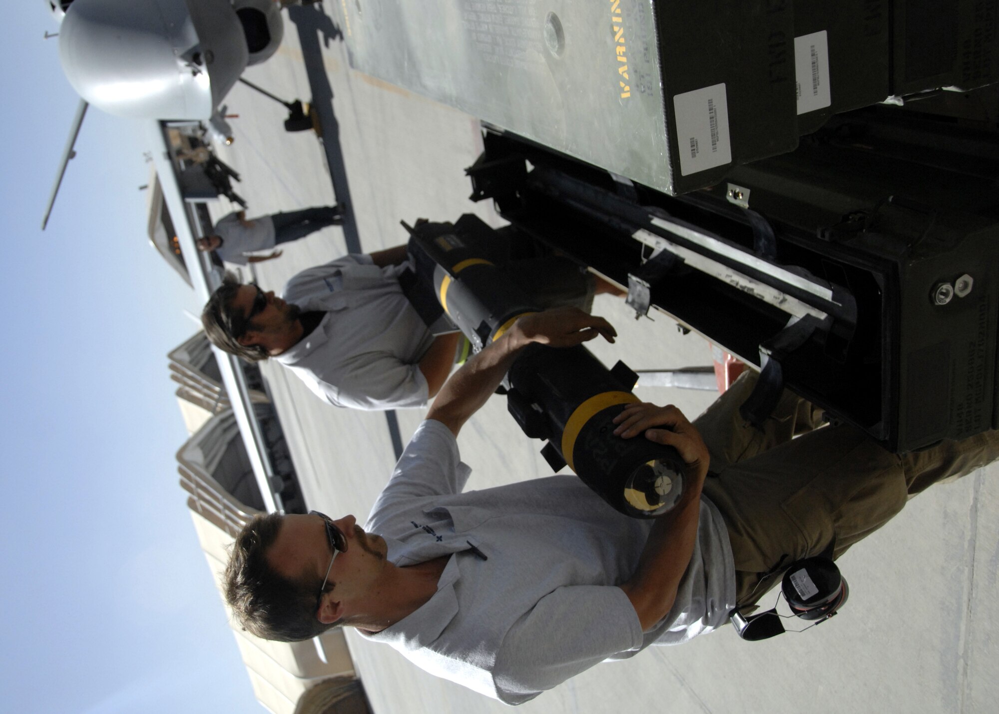 Troy Ruark and Calvin Castleton stow an AGM 114 Hellfire missle after mission recovery here, Oct. 8, 2009. The MQ-9 has a laser rangefinder/designator provides the capability to precisely designate targets for laser-guided munitions. Mr. Ruark and Castleton are aircraft weapons systems technicians from Creech Air Force Base, Nev., and hail from Oakland, Calif., and Salt Lake City, Utah. (U.S. Air Force photo/Senior Airman Timothy Taylor)